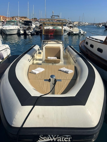 A boat docked at a marina with other boats, a clear sky, and buildings in the background. 4