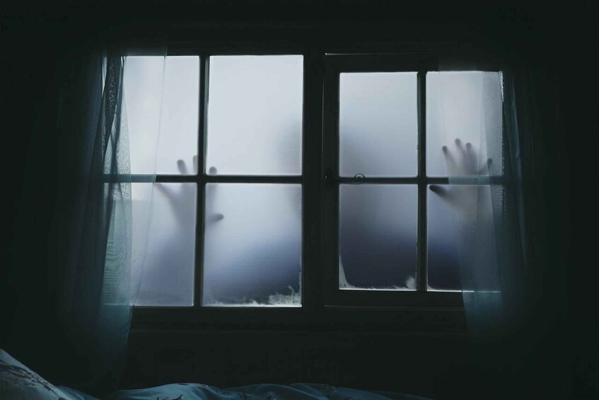 A window with frosted glass and hands reaching through it. 5