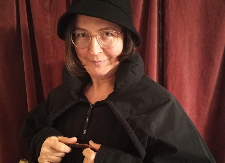 A person wearing a black jacket and a hat, holding a zipper. 1