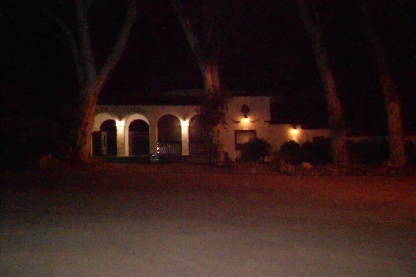 Ein Gebäude mit Rundbogenfenstern und einer Veranda bei Nacht. 3