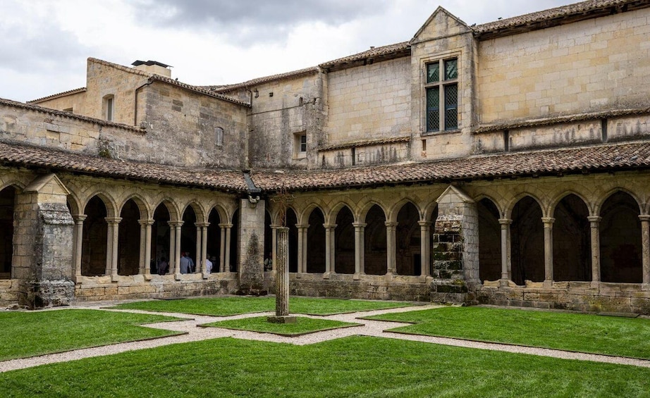 A courtyard with a central fountain, surrounded by stone buildings with arched walkways. 4