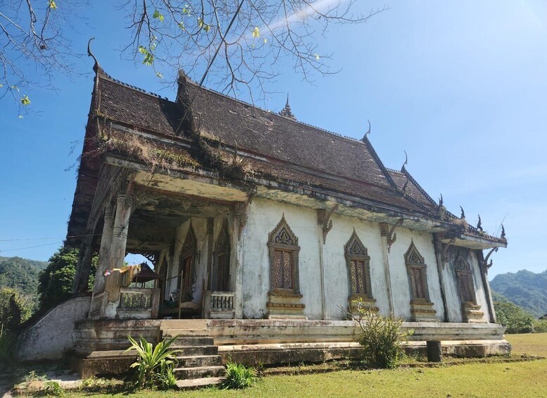 A traditional temple with ornate architecture, a tiled roof, and a stone staircase leading up to the entrance. 1