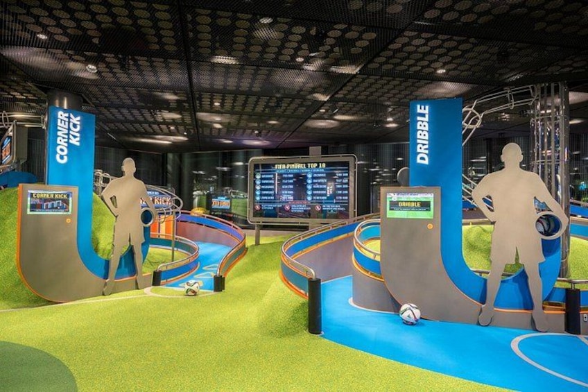 An indoor sports facility with dribble and corner kick training areas, a scoreboard, and a digital display. 4