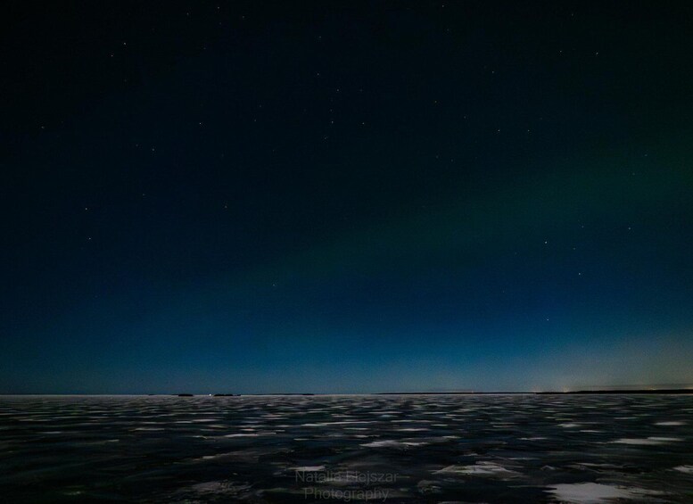 A night sky with stars and the aurora borealis over a calm sea. 4