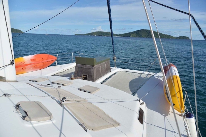 A sailboat's deck with a lifebuoy, a small box, and a cushion. 3