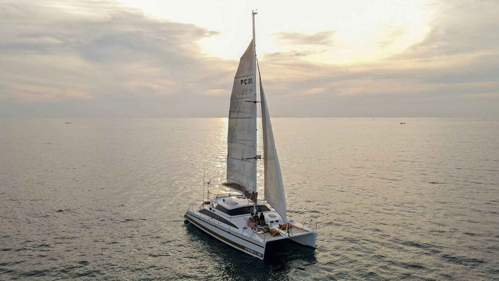 A sailboat with a tall mast and sails, sailing on calm waters. 2