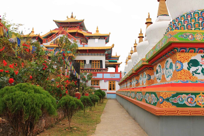 A traditional multi-tiered temple with colorful decorations and a pathway leading to it. 2