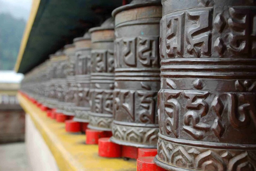 A row of intricately carved prayer wheels. 5