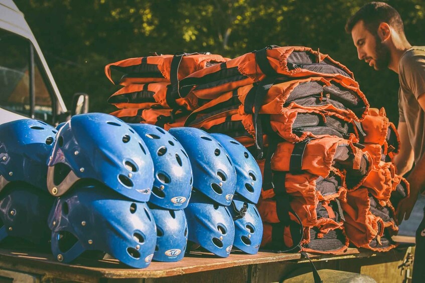 Blue and orange helmets stacked on a table outdoors. 1