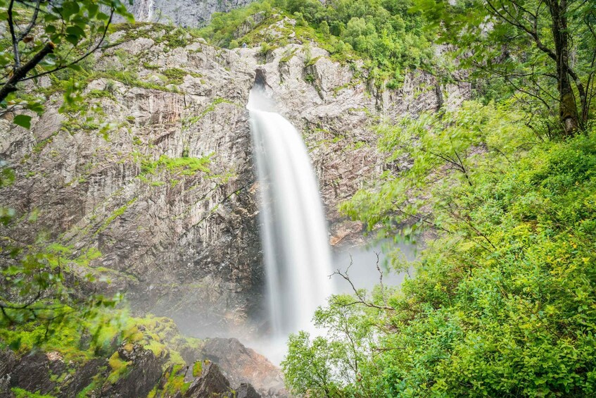 A waterfall surrounded by lush greenery and rocky cliffs. 2