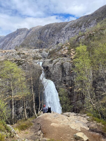 A waterfall in a mountainous area with rocky terrain and sparse vegetation. 4
