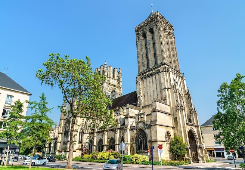 A historic cathedral with a tall tower, surrounded by modern buildings and trees. 3
