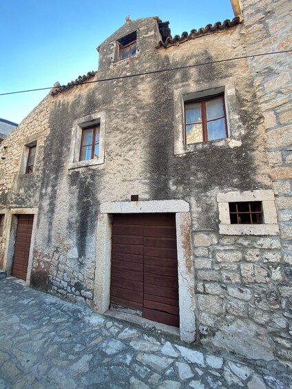 A stone building with a tiled roof, a wooden door, and a small window. 4