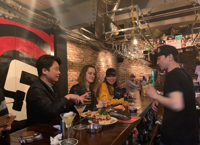 A group of people dining at a restaurant with a brick wall and industrial decor. 5