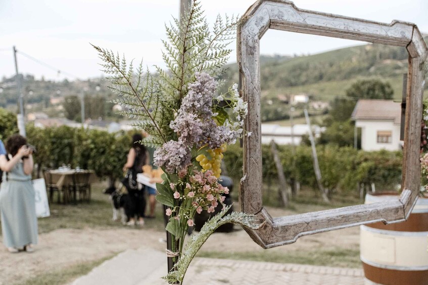 A rustic mirror frame with flowers, a paved path, and a rural landscape with houses in the background. 2