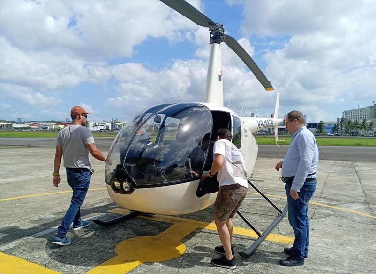 A helicopter on a tarmac with people boarding it. 3