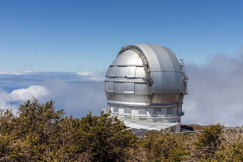 A large observatory dome with a metal staircase and solar panels. 2