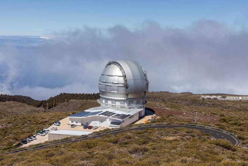 A large observatory dome on a hill with a road leading to it. 1