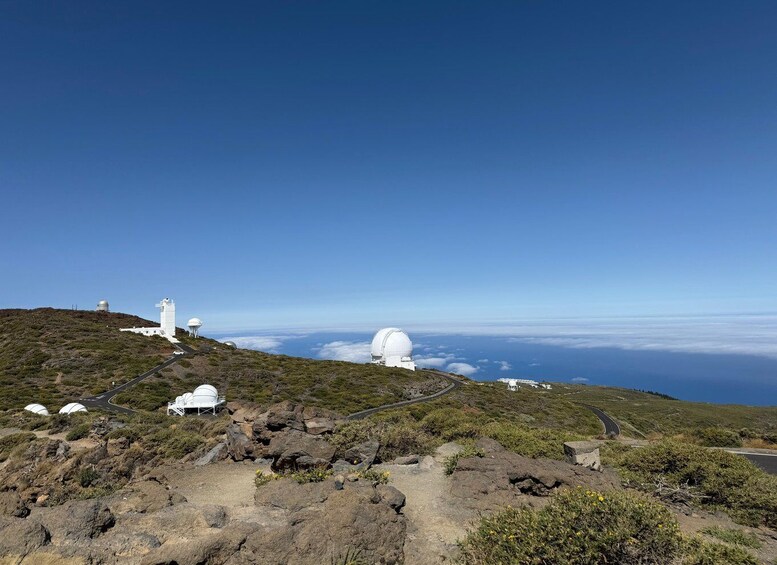 A mountainous landscape with white observatory domes and a winding road. 3