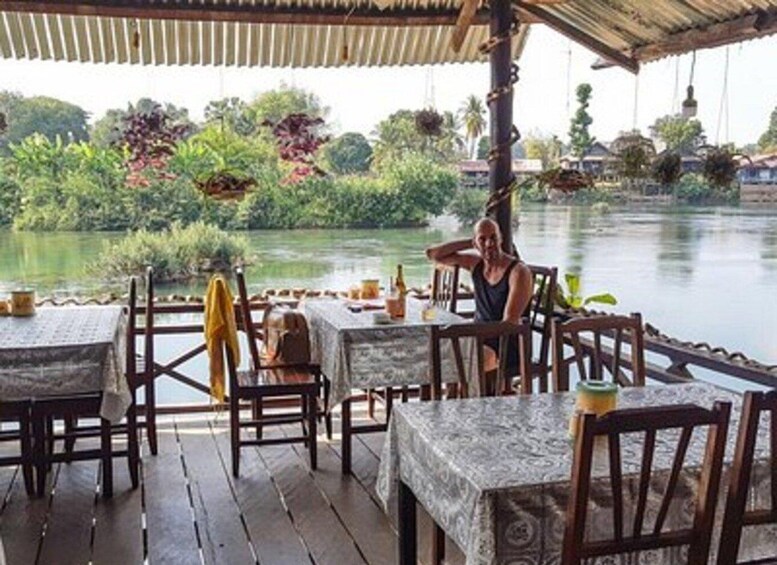 A riverside restaurant with outdoor seating and a view of the water. 3