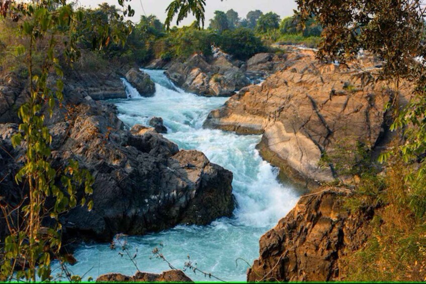A river flowing through a rocky landscape with dense foliage. 4