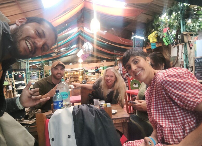 A group of people sitting at a table inside a restaurant with colorful drapes and hanging decorations. 5
