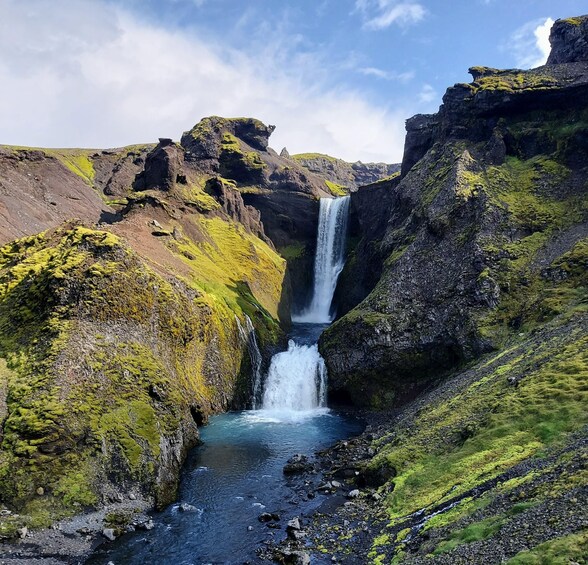 A waterfall in a rocky canyon with green moss. 4