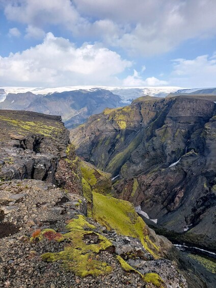 A rugged mountain landscape with rocky outcrops and patches of green moss. 3