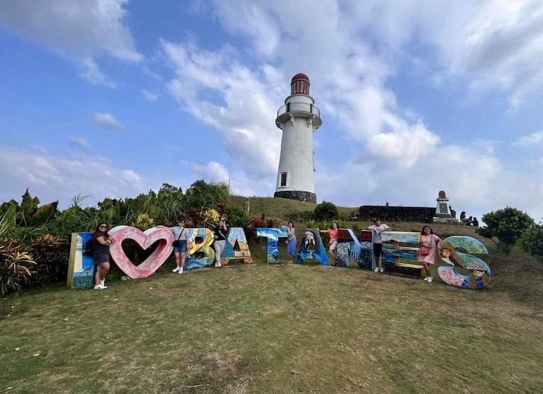 A lighthouse, a grassy hill, and colorful painted letters spelling 'BATAANES.' 4