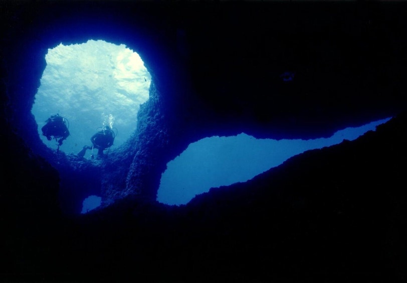 An underwater cave with two divers exploring. 5