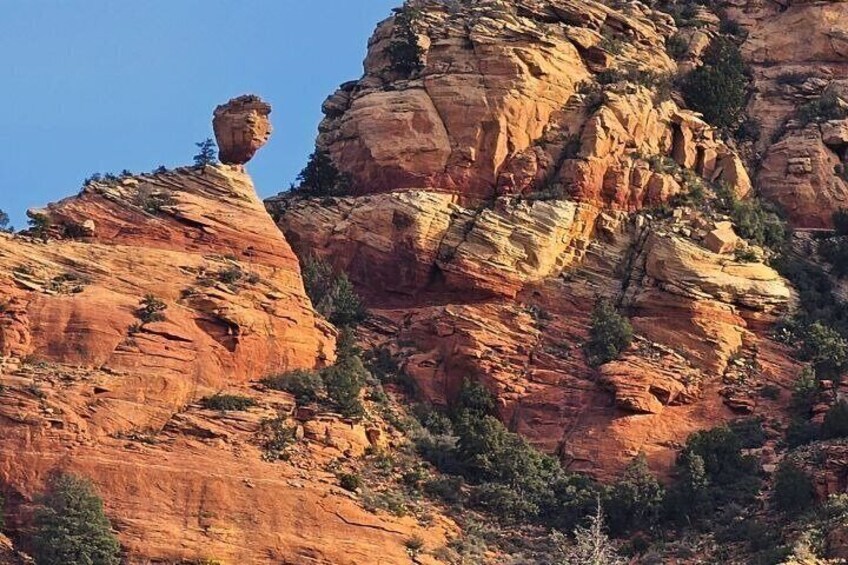 A red rock formation with a prominent overhang. 5