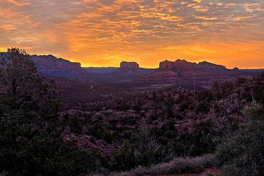 A desert landscape with prominent rock formations and sparse vegetation during sunset. 3