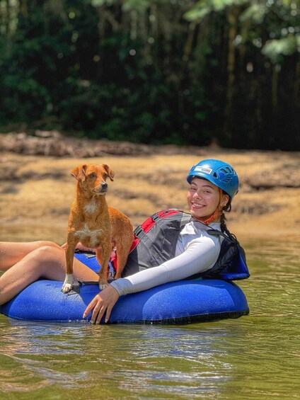 A person in a life jacket floating on a blue water tube with a dog beside them. 5