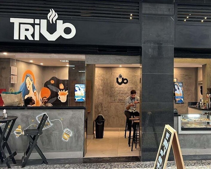 A coffee shop named 'TRiUB' with a modern interior and a person sitting at a table. 3