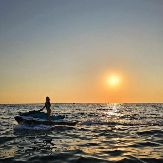 A person on a jet ski in the ocean at sunset. 5