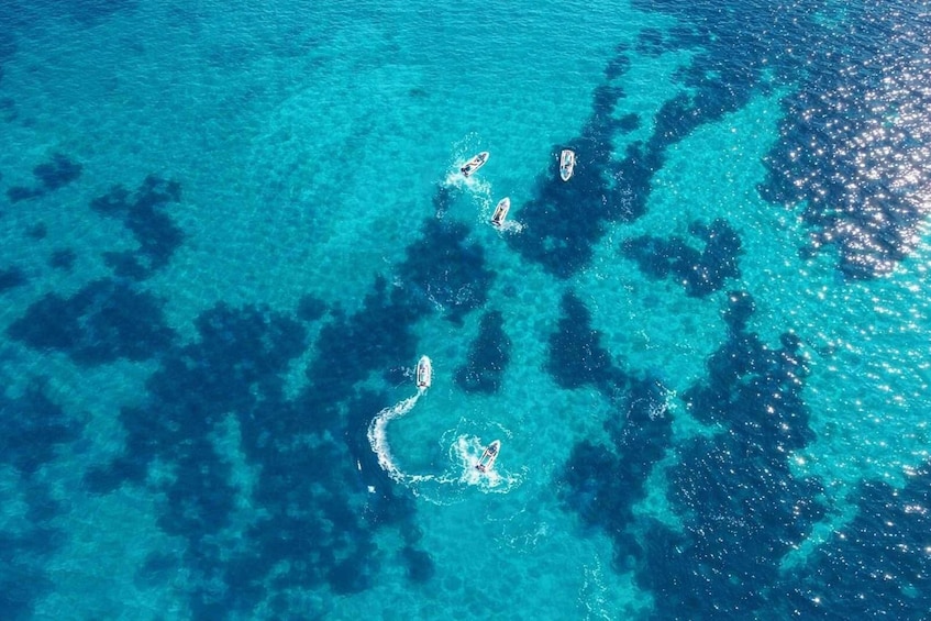 A clear blue sea with three boats. 1