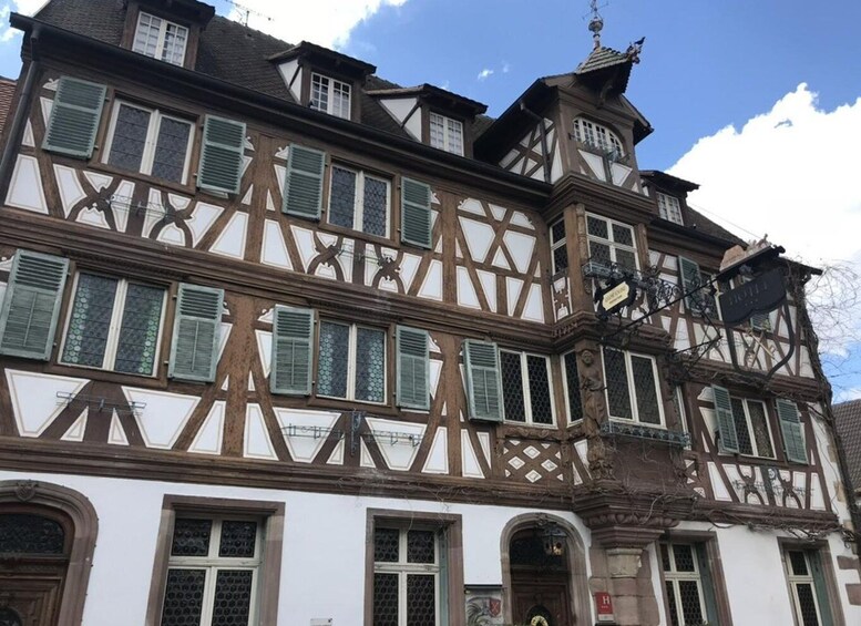 A traditional half-timbered building with multiple windows and a sign indicating a hotel. 2