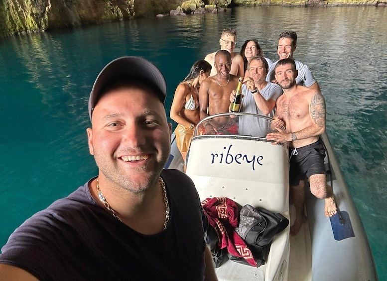 A group of people on a boat with the name 'ribeye' on the side. 1
