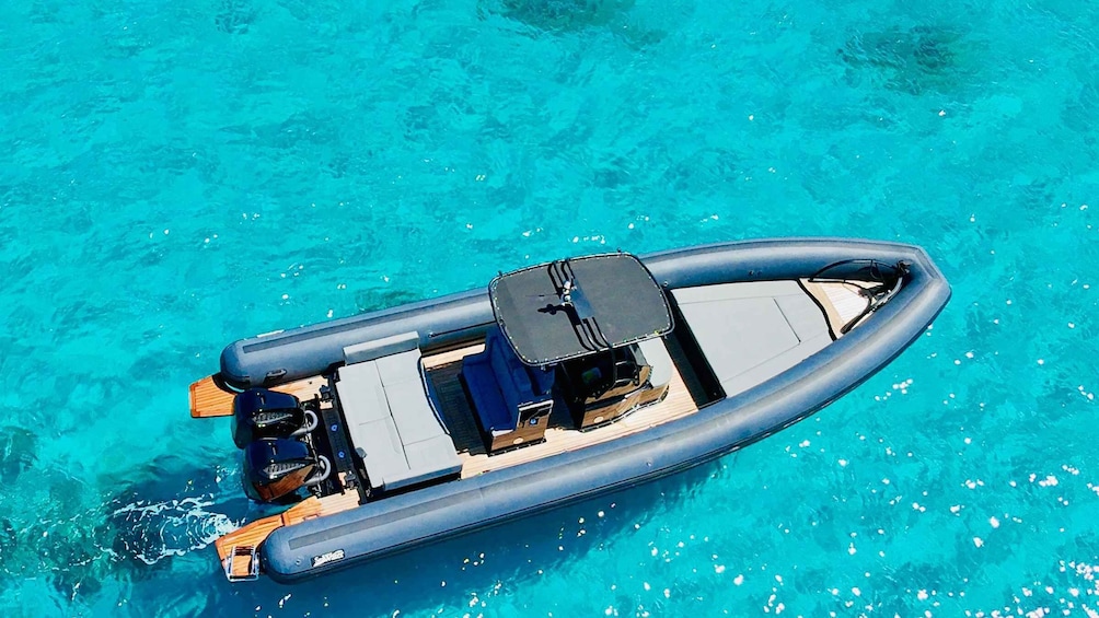 A small inflatable boat on clear turquoise water. 1