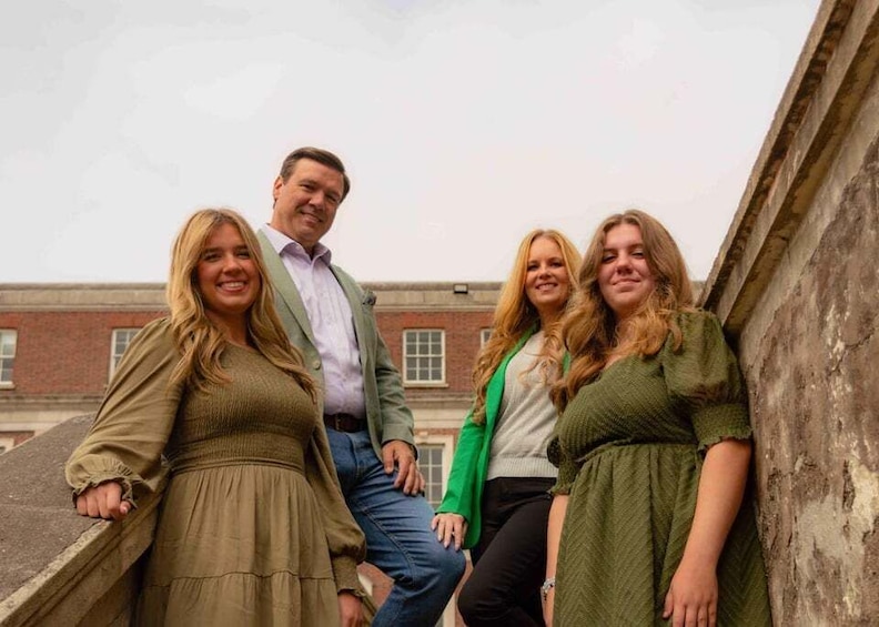 A group of people standing on a staircase with a brick building in the background. 2