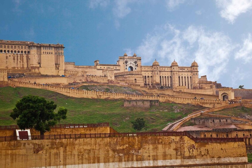 A large, historic fort with multiple towers and a central gate, surrounded by a hilly landscape. 1