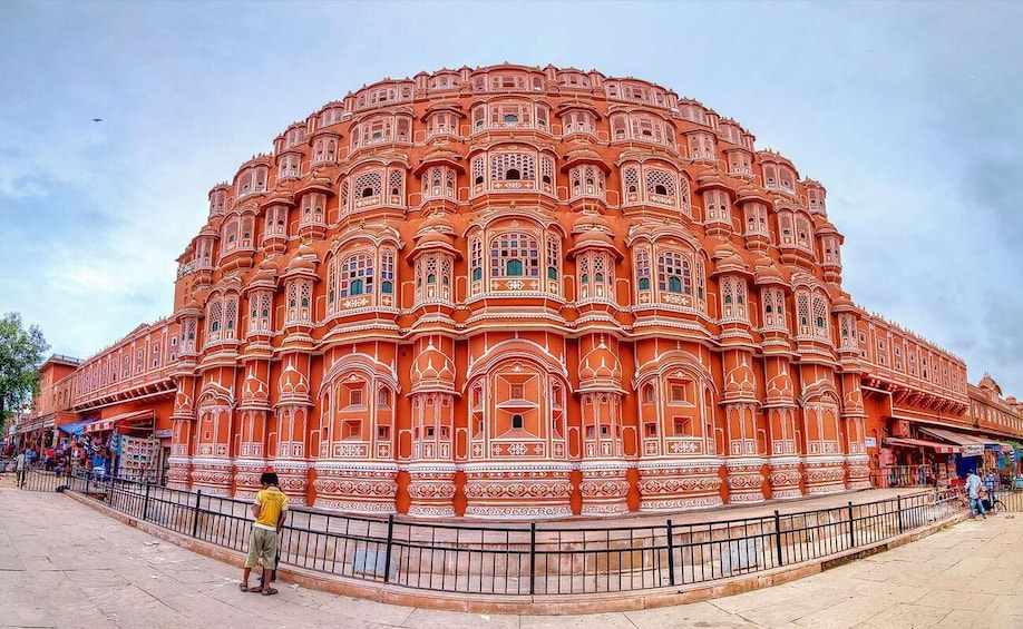A large, ornate building with intricate architectural details and a surrounding fence. 4