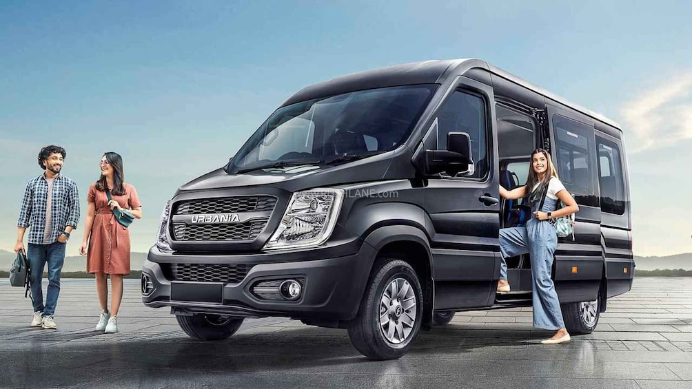 A black URBANIA van with a modern design, large windows, and a prominent front grille. 5