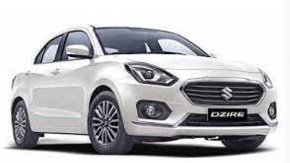 A white Suzuki car with a front grille and headlight design. 5