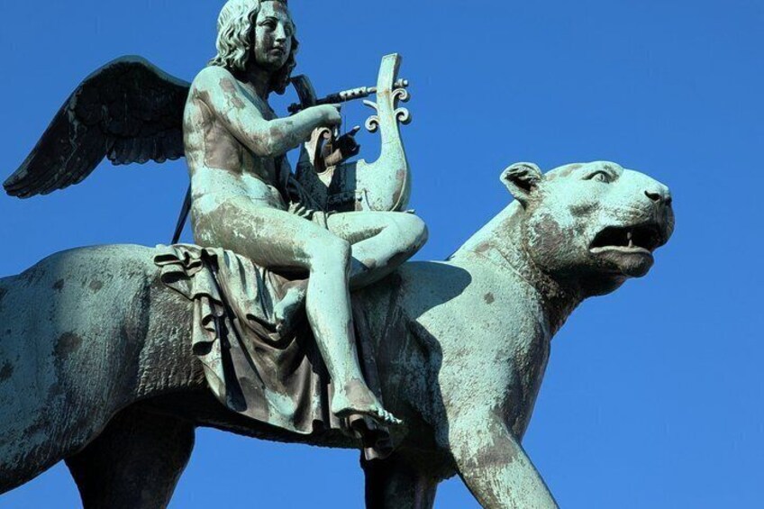 A statue of an angel playing a lyre on a lion's back. 5