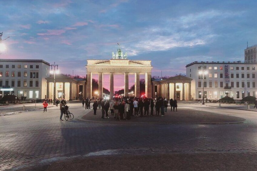 The Brandenburg Gate surrounded by people and buildings. 2