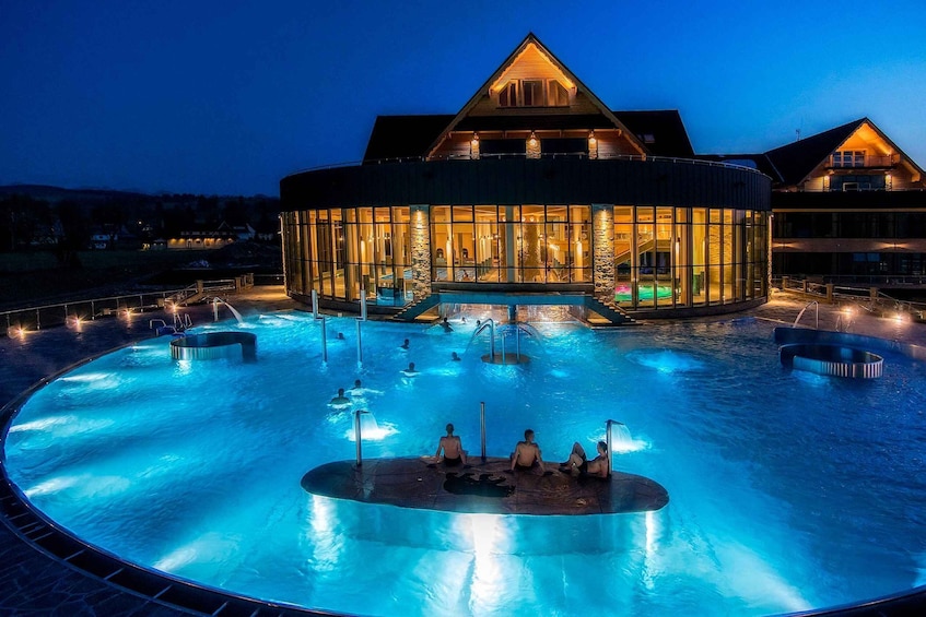 A large indoor swimming pool with a glass-enclosed building in the background. 2