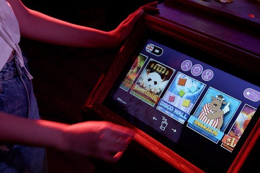A person using a touchscreen device with game icons. 4