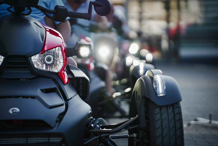 A motorcycle with a red headlight and a rider in the background. 1