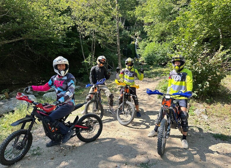 Three mountain bikers on a dirt trail surrounded by trees. 5
